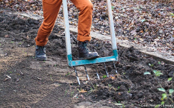Jardinier qui plante un outil pour travailler la terre